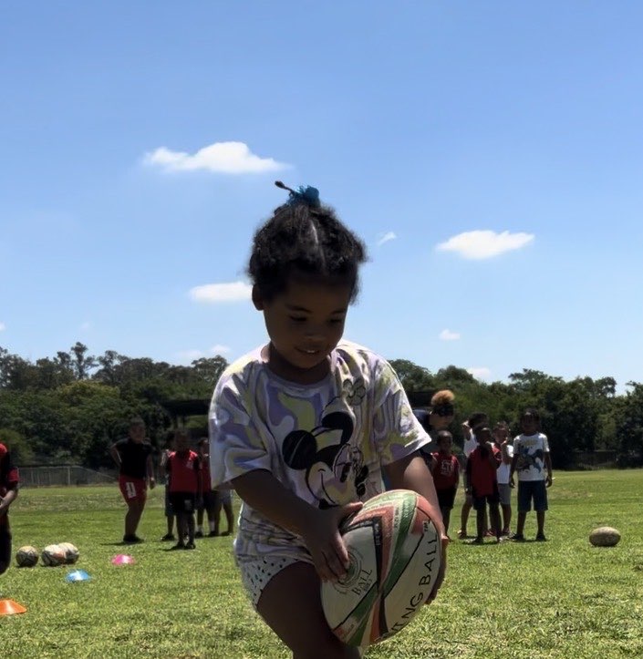 A child learning to catch a rugby ball